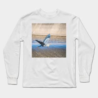 Great Blue Heron In Flight Over the Spillway by Debra Martz Long Sleeve T-Shirt